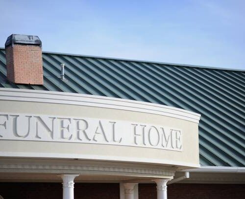 Close up of funeral home sign engraved on curved building front with copy space above